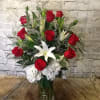 Red roses and white lilies in a clear glass vase