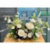 White roses arranged around a clear cross centerpiece