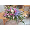 Pink and white floral bouquet with lilies and roses, tied with a lavender ribbon