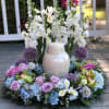 White floral wreath with lavender roses and a ceramic urn centerpiece