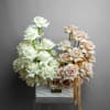 Arrangement of white and blush roses in a white rectangular vase