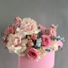 Pink and white roses arranged in a pink box