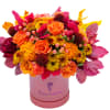 Orange and yellow mixed bouquet in a pink hatbox with magenta foliage