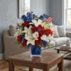 Red roses, white lilies, red carnations and pale alstroemeria with vivid blue