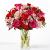 We blend soft pink roses and carnations with lush greenery into a
