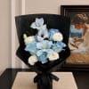 Blue and white bouquet wrapped in black paper with a ribbon