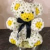 Teddy bear made of white and yellow flowers with a black ribbon