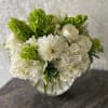 White and green bouquet in a clear glass vase