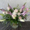 Pink roses and lilies arranged in a glass vase