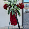 Large red rose standing spray with white orchids on an easel
