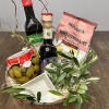 Gift basket with olive oil, olives, crackers, and a small dish