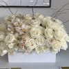 White roses and orchids arranged in a rectangular white box