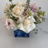 Bouquet of white roses and pale pink flowers in a blue glass vase