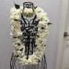 A full, ceremonial white carnation lei creates an immediate sense of reverence