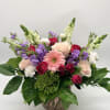 A dreamy mix of blooms designed in a delicate pink vase. 

Shades