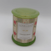 A floral-patterned scented candle in a green tin container