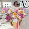 Large bouquet of pink, white, and yellow flowers in a gold box