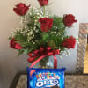 Red roses in a glass vase with a red ribbon and a birthday Oreo cookie package
