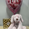 Heart-shaped "I Love You" balloon with a pink plush dog and chocolates
