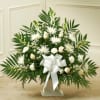White floral standing spray with a large white bow