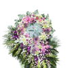 A serene circular wreath of pastel pink, lavender, and white blooms makes