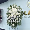 White roses, lilies, chrysanthemums, carnations and stock arranged with palm fronds on