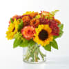 Bouquet of sunflowers, roses, and mums in a clear glass vase