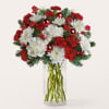 Red and white flowers arranged in a clear glass vase