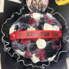Black-wrapped bouquet of red, white, and black roses with a horror-themed topper
