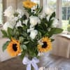 Bouquet of white roses, white alstroemeria, and sunflowers in a glass vase
