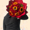 Bouquet of red roses and yellow sunflowers wrapped in red paper