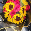 Bouquet of pink roses and yellow sunflowers wrapped in black paper