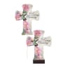 Two cross-shaped memorial plaques with pink flowers and hummingbirds