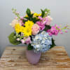 A colorful assortment of blooms of roses, hydrangeas, stock, and daisies in