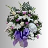 White and pink mixed flower arrangement in a vase with a purple ribbon