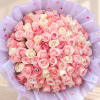 Large bouquet of pink and white roses wrapped in lavender paper