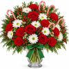 Red and white floral arrangement in a glass vase with candy canes