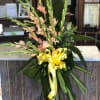 Tall floral spray with peach gladiolus and a yellow ribbon
