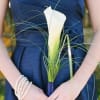 Woman holding a white calla lily bouquet with long grass accents