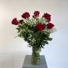 Red roses in a clear glass vase with baby's breath