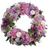 Circular wreath of pink and purple flowers with green foliage