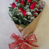 Bouquet of red roses wrapped in brown paper with a red ribbon