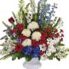 Mixed red, white, and blue floral arrangement in a white vase