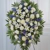 White and blue funeral spray on a standing easel
