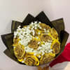 Bouquet of gold roses with white baby's breath in black wrapping