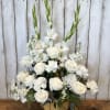 White roses and gladiolus in a pumpkin-shaped container