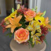 Bouquet of orange-pink roses and yellow flowers in a basket