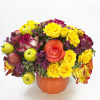 Pumpkin-shaped vase with yellow and coral roses and decorative fruit accents