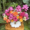 Bright mixed rose arrangement in a white pumpkin vase
