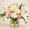 Pink and white bouquet with lilies, roses, and carnations in a glass vase